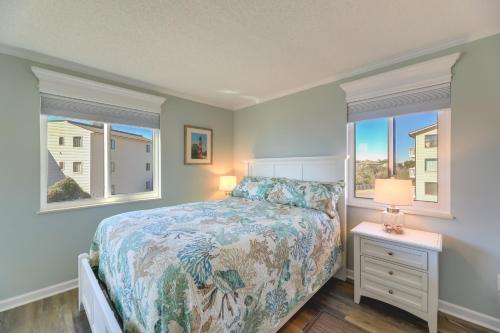 a bedroom with a bed and two windows at Emerald Isle Vacation Rental with Resort Pool! in Emerald Isle
