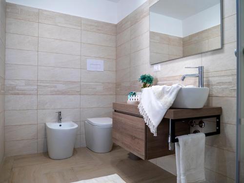 ein Bad mit einem Waschbecken und einem WC in der Unterkunft Flower House in Santo Stefano di Camastra