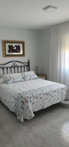 - une chambre avec un lit et une couette à fleurs dans l'établissement Alojamiento en Portonovo Playa, à Sanxenxo