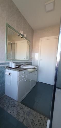 La salle de bains est pourvue d'un lavabo et d'un miroir. dans l'établissement Alojamiento en Portonovo Playa, à Sanxenxo