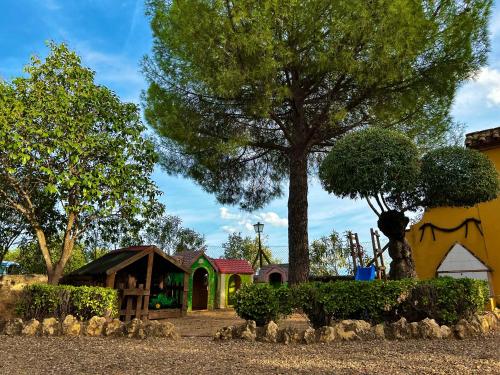 a playground with a play house and a tree at Casa Rural Mirador de la Alcaidía in Hornachuelos