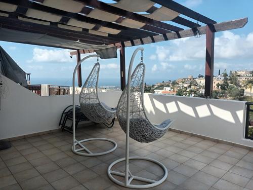 a balcony with two hammocks on a roof at Paschali Sunset Appartment in Peyia