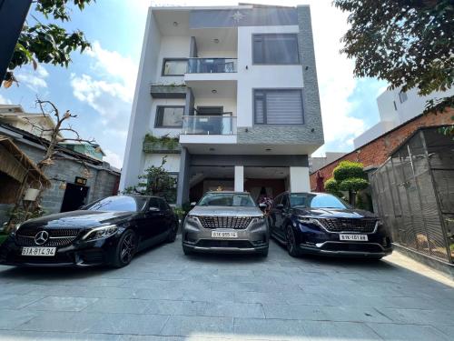 três carros de luxo estacionados em frente a um edifício em Khách Sạn K’My em Ấp Phú Thọ