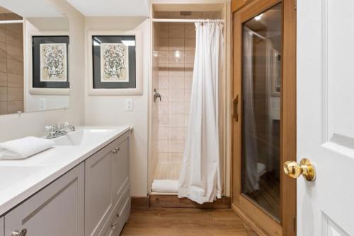 a bathroom with a sink and a shower at 3 Level Ski Chalet 7BR w Deck, Sauna & Ping-Pong! in Blue Mountains