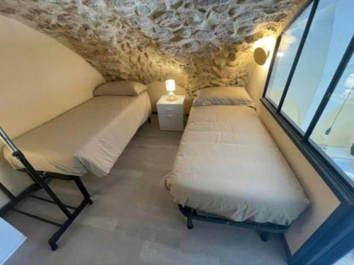 Habitación pequeña con 2 camas y ventana en Puteha - Arco Pronti, en SantʼAgata di Puglia