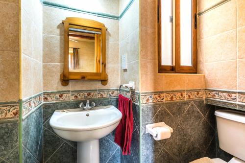 a bathroom with a sink and a toilet and a mirror at Ta Debora 3 bedroom Villa with private pool in Xagħra