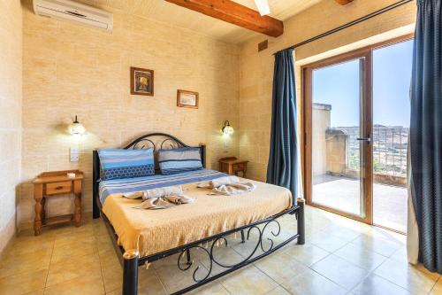 a bedroom with a bed with towels on it at Ta Debora 3 bedroom Villa with private pool in Xagħra
