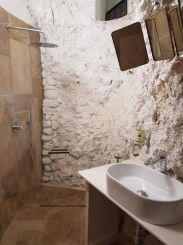 a bathroom with a sink and a stone wall at Cafuorchie - Arco Pronti in SantʼAgata di Puglia