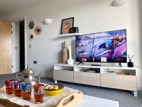 a living room with a tv and a table at Cosy Egyptian Inspired Apartment Northampton in Northampton