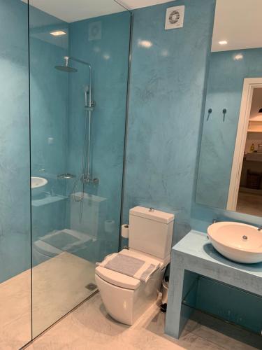 a bathroom with a shower and a toilet and a sink at Paradise Design Apartments in Batsi