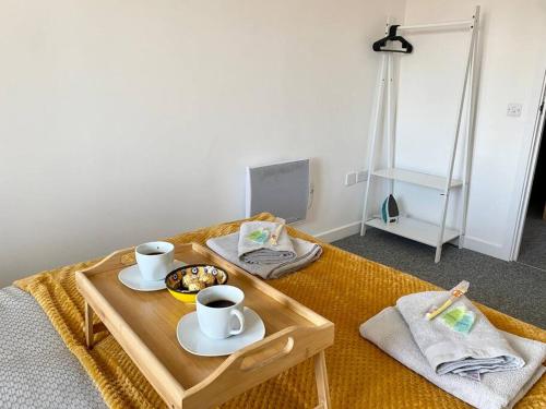 a coffee table with two cups and a plate of food at Cosy Egyptian Inspired Apartment Northampton in Northampton