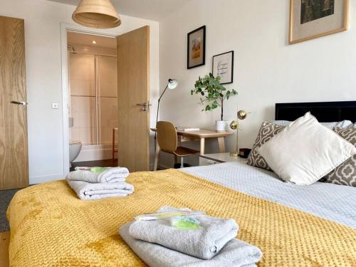a bedroom with a bed with towels on it at Cosy Egyptian Inspired Apartment Northampton in Northampton