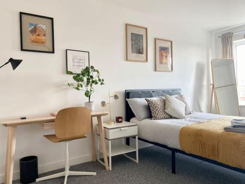 Cosy Egyptian Inspired Apartment Northampton في نورثامبتون: غرفة نوم بسرير ومكتب وكرسي