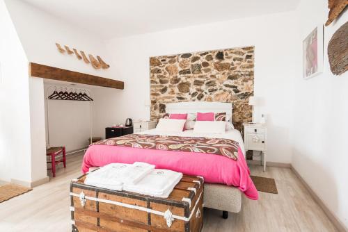 sypialnia z dużym łóżkiem i kamienną ścianą w obiekcie Monte de Portugal w mieście Montargil
