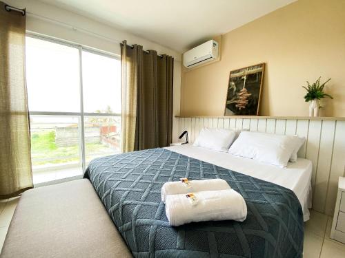 ein Hotelzimmer mit einem Bett mit Handtüchern darauf in der Unterkunft Vista mar incrível pertinho do Beach Park in Aquiraz