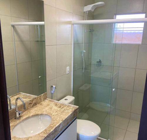 ein Badezimmer mit Dusche, Waschbecken und Toilette in der Unterkunft Vista mar incrível pertinho do Beach Park in Aquiraz