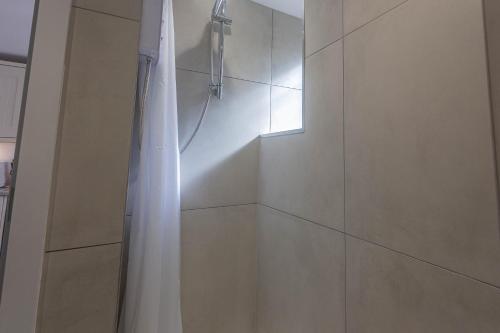 a shower with a white shower curtain in a bathroom at Cosy 1 bedroom Cottage - Great location & Parking in Penzance