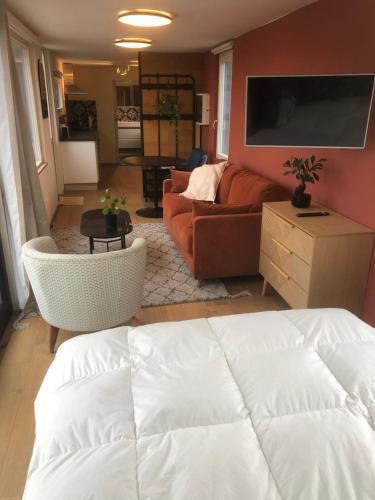 een woonkamer met een bank en een tv bij L Antre Vous in Bergen