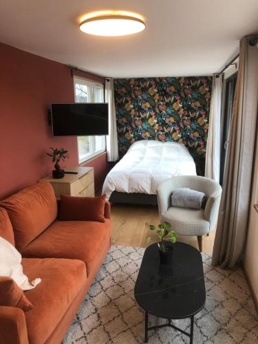 een woonkamer met een bank en een bed bij L Antre Vous in Bergen