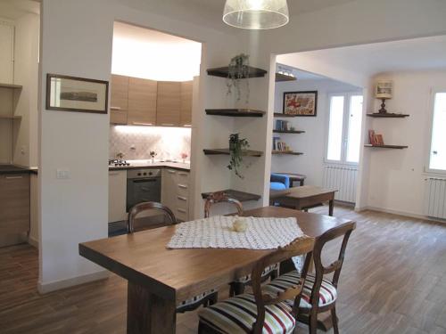 Il comprend une cuisine et une salle à manger avec une table et des chaises en bois. dans l'établissement Appartamento Santa Croce, à Florence