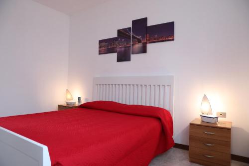 una camera con letto rosso e due comodini di Appartamento da Luca a Calasetta