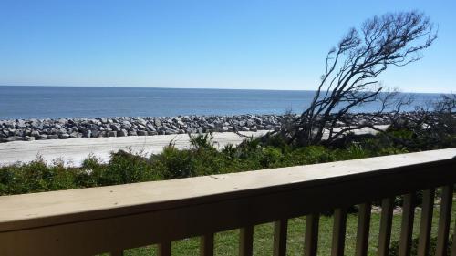 a balcony with a view of a beach and a fence at Villas by The Sea Deluxe Two Bedroom Apartment in Jekyll Island