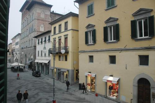 a group of people walking down a street next to buildings at B&B Al Canto del Cavour in Pistoia