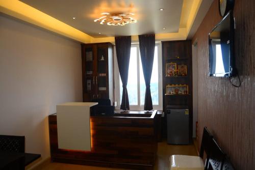 Vanam Holidays Inn في أوتي: غرفة معيشة مع نافذة وثلاجة