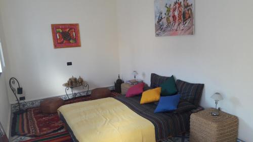 Un dormitorio con una cama con almohadas de colores. en Taghart, la belle demeure, en Essaouira