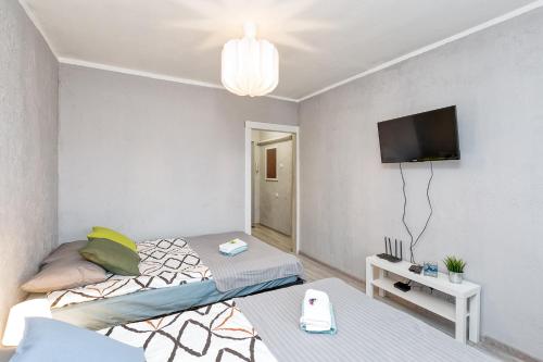a bedroom with a bed and a tv on a wall at Dubnas iela - 6 can stay in Rīga