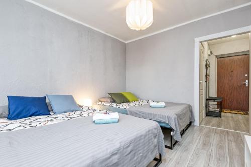a bedroom with two beds and a chandelier at Dubnas iela - 6 can stay in Rīga