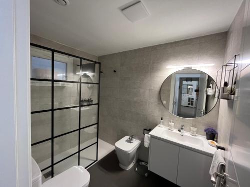 y baño con aseo, lavabo y espejo. en Villa Bobita-Marina Golf-Playa Granada en Motril