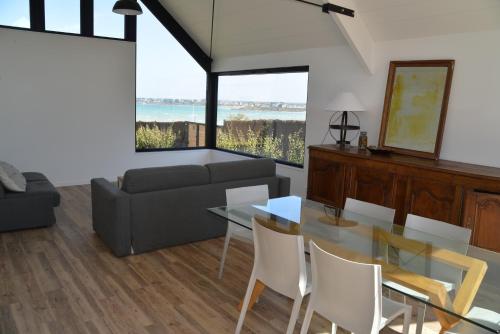 a living room with a glass table and a couch at Villa 1 in Saint-Jacut-de-la-Mer