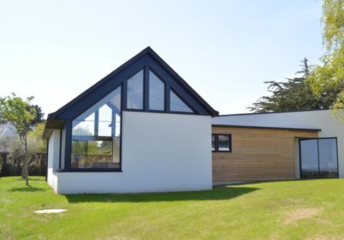 a modern house with a large window and a yard at Villa 1 in Saint-Jacut-de-la-Mer