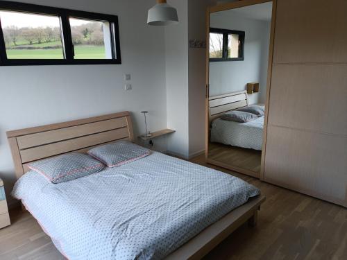 a bedroom with a bed and a large mirror at maison moderne à la campagne in Bezinghem