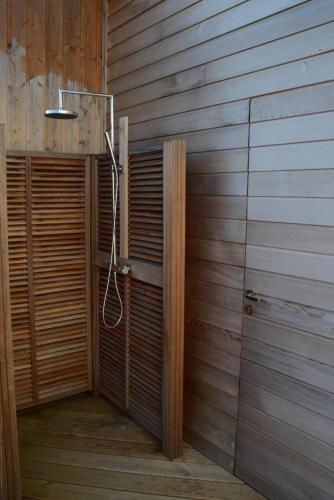 La salle de bains est pourvue d'une douche et d'un mur en bois. dans l'établissement Villa 1, à Saint-Jacut-de-la-Mer