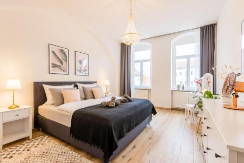 a bedroom with a large bed and two windows at Fynbos Apartments Theaterblick, Netflix, Parkplatz in Meißen