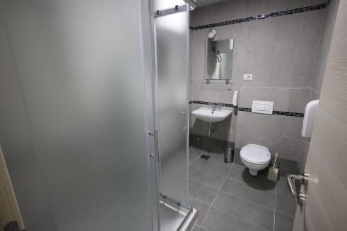 a bathroom with a shower and a toilet and a sink at Konačište Grad B&B in Užice