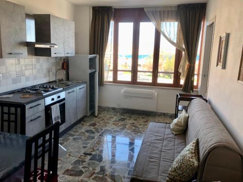 een woonkamer met een bank en een keuken bij Delos e Artemide in Siracusa