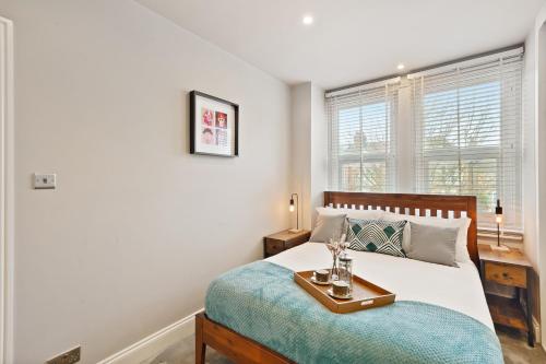 เตียงในห้องที่ Stylish 2 Bed, Business & Leisure. Wifi and private garden; by First Serve - West Wimbledon