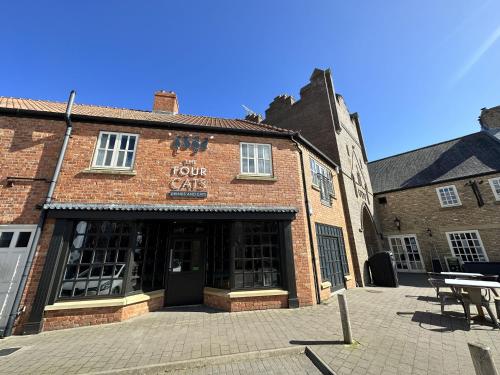 a brick building with a tour cafe in front of it at Spoonbill Cottage in Filey
