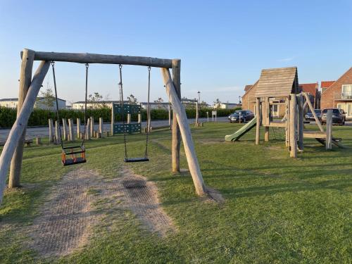 a playground with a swing set in the grass at Spoonbill Cottage in Filey