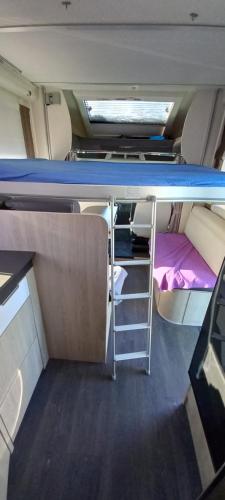 Mały pokój z łóżkiem piętrowym i łóżkiem piętrowym w obiekcie Nuit en Camping car : une experience immersive w mieście Segonzac