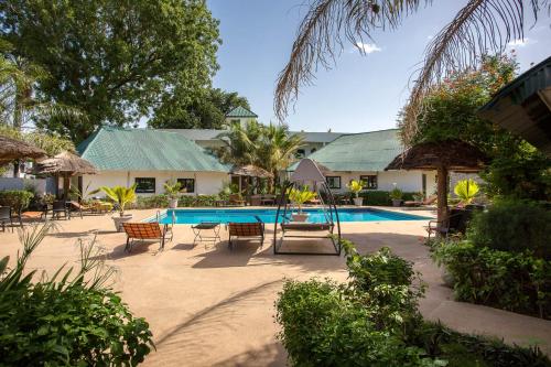 un complexe doté d'une piscine avec des chaises longues et des parasols dans l'établissement Le Bedik de Kédougou, à Kédougou