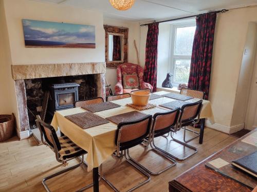 Un comedor con mesa y sillas y chimenea. en Black Dog House, en Bishop Auckland