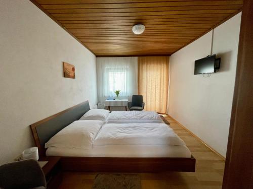 a bedroom with a large bed and a desk at Privatzimmer Haider in Illmitz