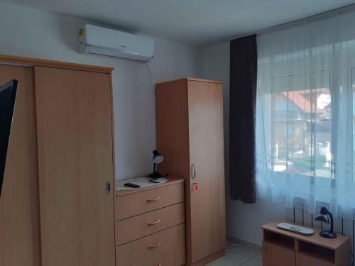 a bedroom with a dresser and a window and a cabinet at Apartment in Heviz/Balaton 36758 in Hévíz