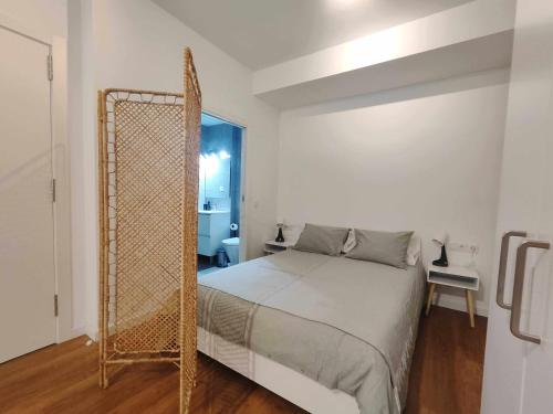 biała sypialnia z łóżkiem i lustrem w obiekcie Mazi Apartments Loft w mieście Mataró