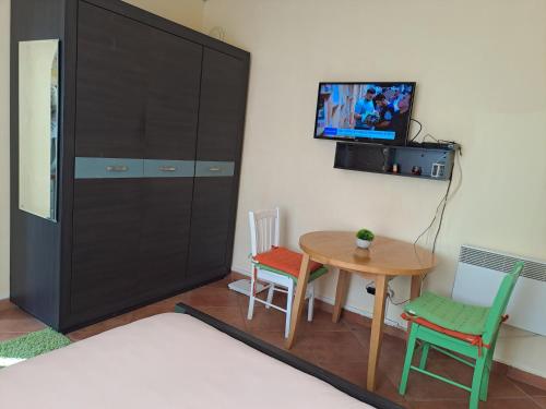 Pokój ze stołem, szafką i telewizorem w obiekcie Sinemorets apartment w mieście Sinemorec
