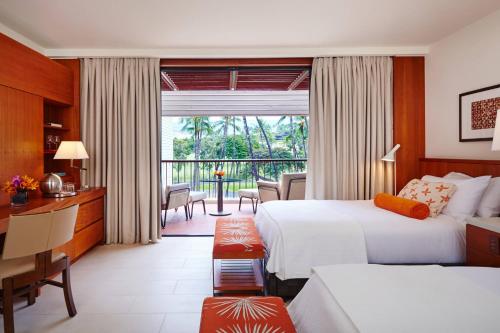a hotel room with two beds and a balcony at Mauna Kea Beach Hotel, Autograph Collection in Hapuna Beach